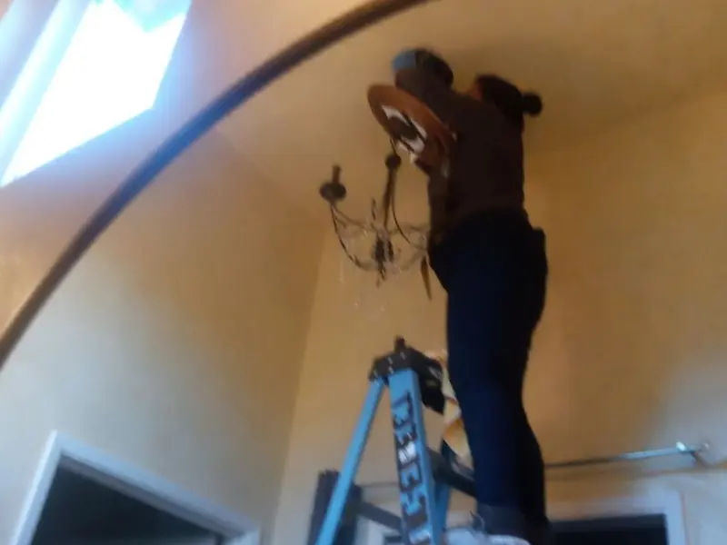 Electrician installing a chandelier in a Richmond residence